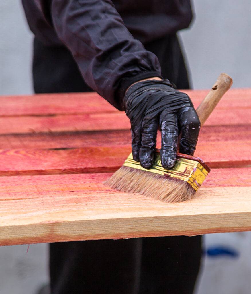 a man treats a board with a red antiseptic select 2024 02 19 20 59 49 utc